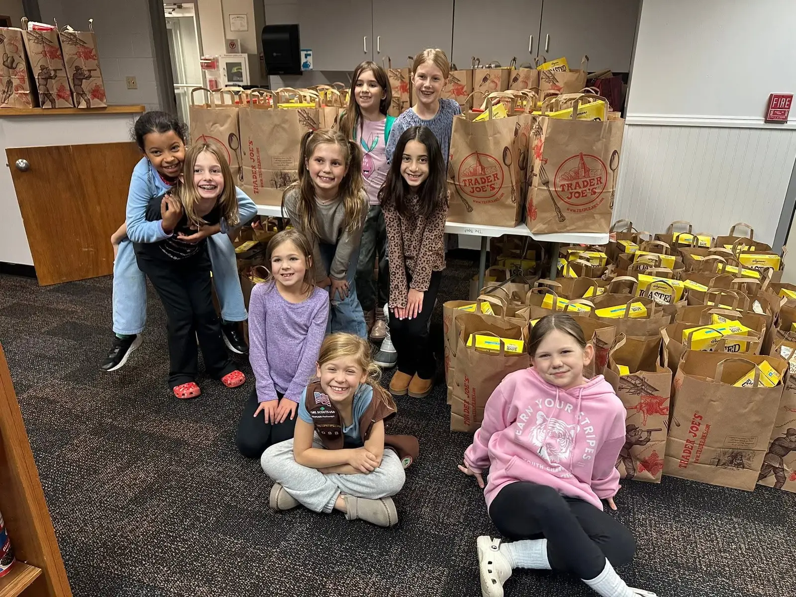 A Girl Scout troop with grocery bags they packed for The Spot